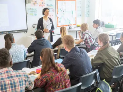 Students sitting in a classroom with teacher giving a lecture.