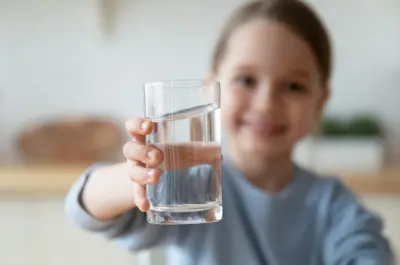 Young girl holding glass of water