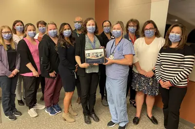 Image of Dr. Bocking handing a plaque to staff.