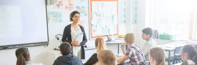 Students sitting in a classroom with teacher giving a lecture.