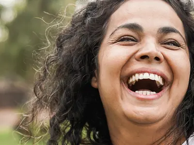 Woman with a child on her back both smiling and happy
